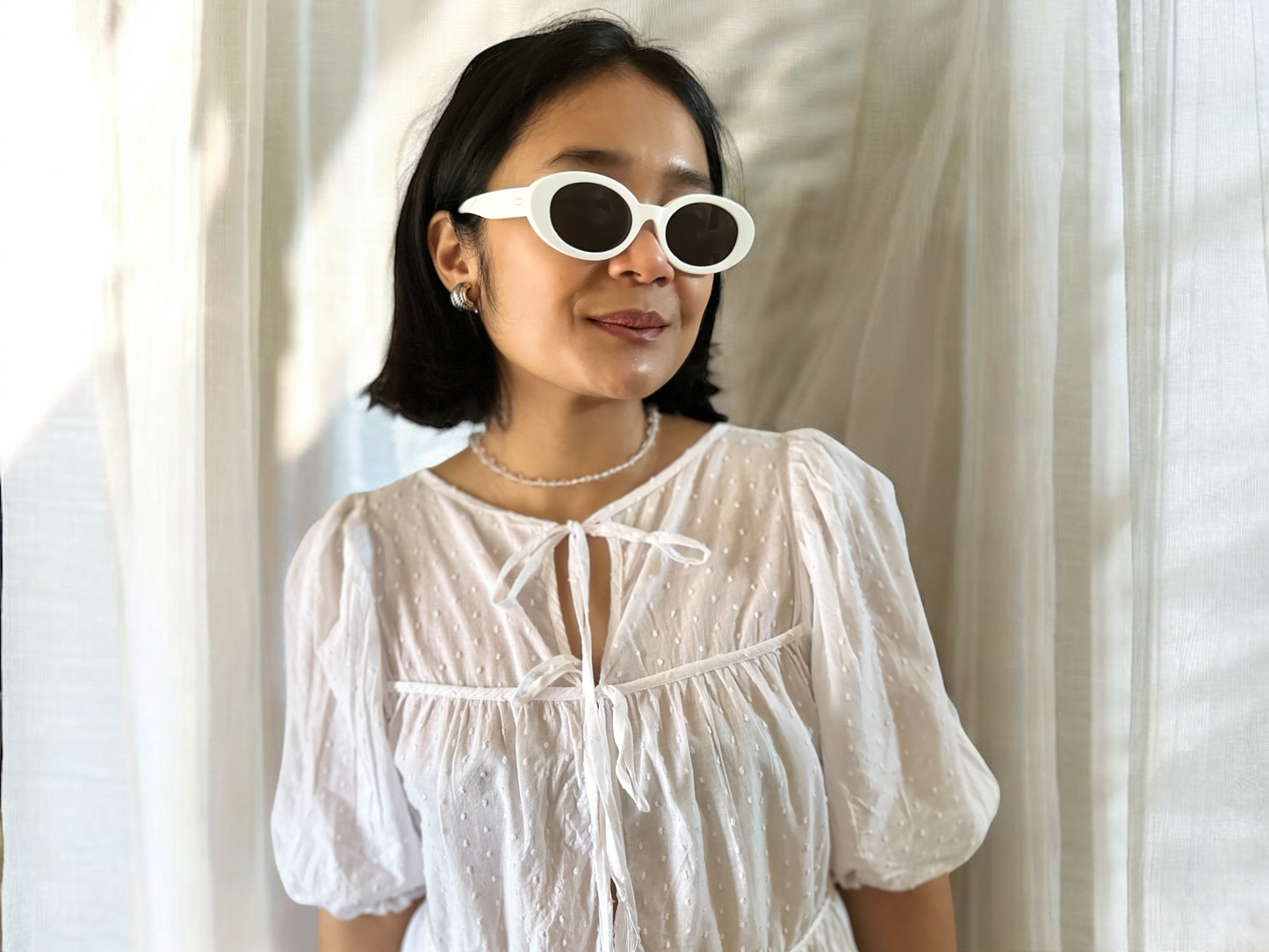 A Pair of Bambi Oval Polarised Acetate Sunglasses White On Model with white background