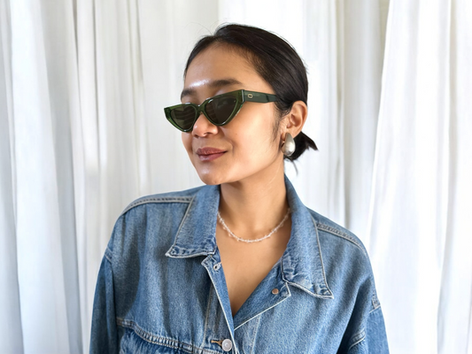 Model wearing Green Cat Eye Polarised Acetate Sunglasses with a denim jacket, standing against a white curtain backdrop